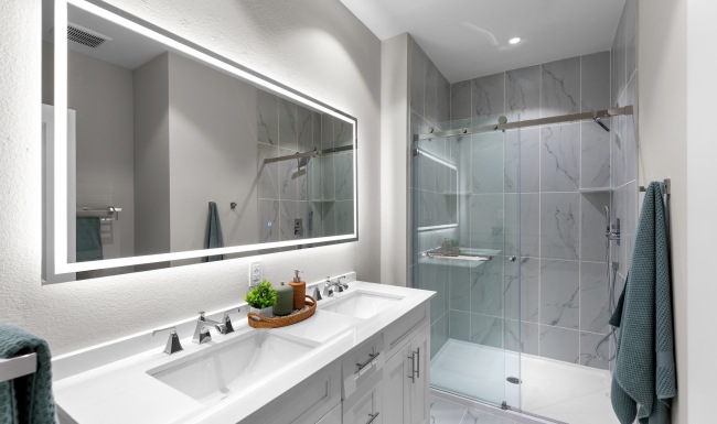 a bathroom with a shower, sink and mirror